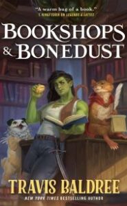 Image shows a green female ogre holding a bun, carrying a sword and an an open book, a rat with a quill pen and a notebook, and a pet that looks like a dog with an owl head. They are all in a bookshop. Text reads: Bookshops & Bonedust Travis Baldree New York Times Bestselling Author." Cover blurb says: "'A warm hug of a book.'–T Kingfisher on Legends & Lattes."